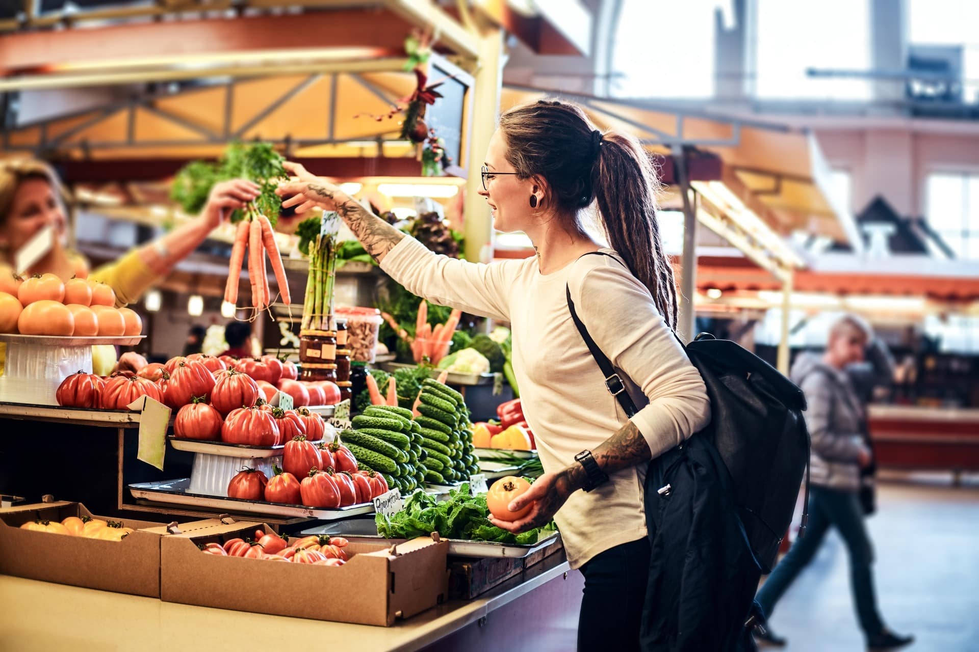 beatiful-pensive-girl-in-glasses-is-buying-fresh-carrots-at-local-farmer-s-marketm Kobieta robi zakupy na hal spożywczej